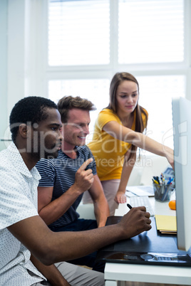 Graphic designers working on computer at desk