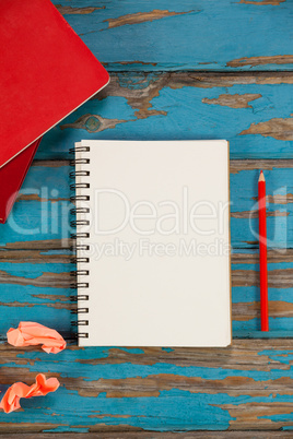Notepad, pencil, red books and crumpled paper