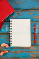 Notepad, pencil, red books and crumpled paper