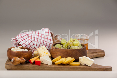 Loaf of bread with cheese, knife and jam