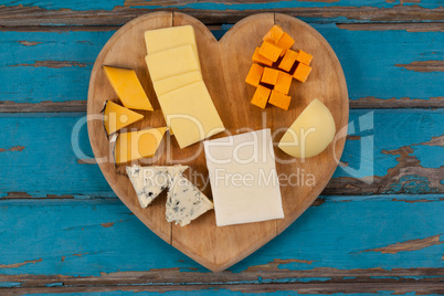 Variety of cheese on heart shaped chopping board