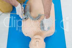 Paramedic practicing resuscitation on dummy