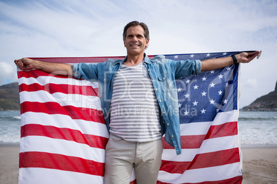 Man holding american flag on beach