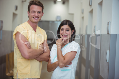 Portrait of female and male nurse standing in corridor