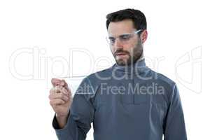 Man wearing protective eyewear holding a glass sheet
