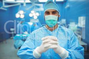 Portrait of male surgeon praying in operation theater
