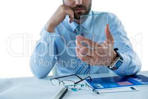 Businessman sitting at table holding a glass sheet