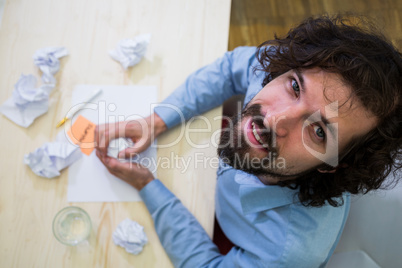 Graphic designer crumpling paper at his desk