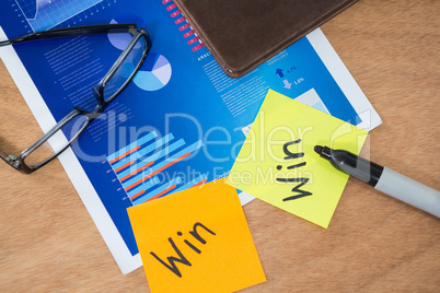 Win written on sticky note with marker spectacles and graph