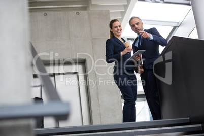 Business colleagues standing on a staircase and talking to each other