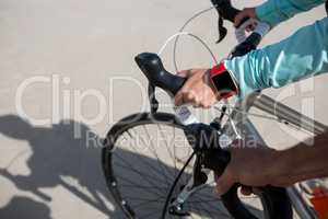 Close-up of couples hand wearing smartwatch while riding bicycle