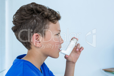 Boy using asthma pump