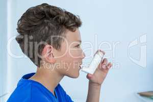 Boy using asthma pump