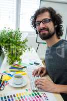 Graphic designer working on computer at his desk