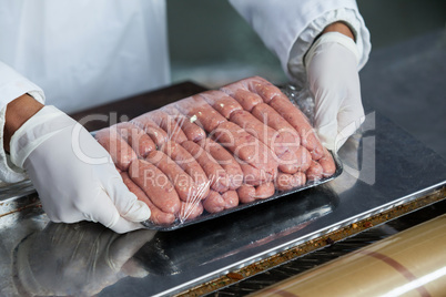 Butcher packing raw sausages