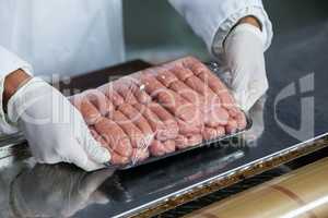 Butcher packing raw sausages