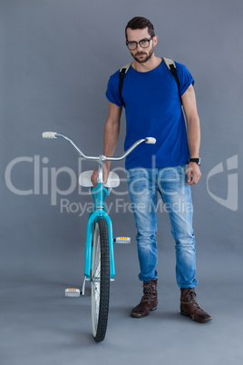 Man in blue t-shirt and backpack with a bicycle