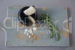 Gouda cheese with rosemary leaves on chopping board