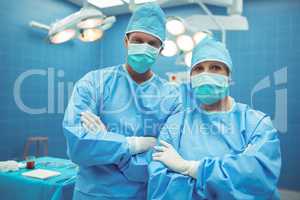 Portrait of male and female surgeon standing in operation theater