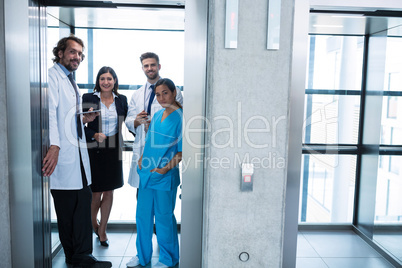 Doctors and businesswoman standing in elevator