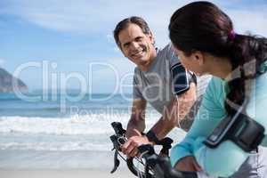 Couple leaning on bicycle while interacting with each other