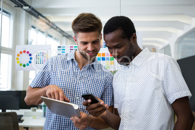 Graphic designers discussing over digital tablet and mobile phone