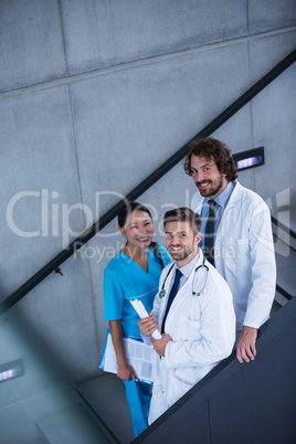 Doctors and nurse holding medical reports standing on stairs