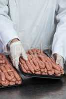 Butcher packing raw sausages