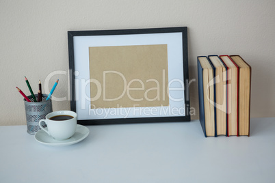 Books with picture frame and a cup of coffee
