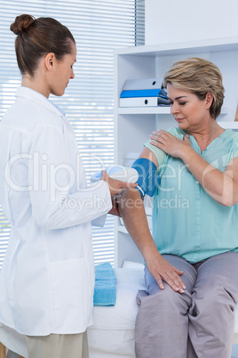 Female doctor checking blood pressure of a patient