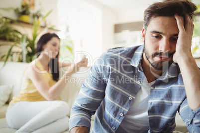 Upset couple ignoring each other on sofa