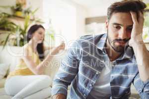 Upset couple ignoring each other on sofa