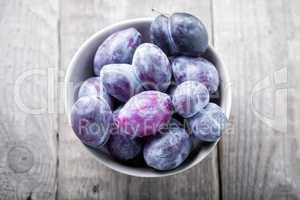 Fresh and ripe Plums on a wooden table.