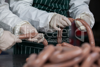Butchers processing sausages