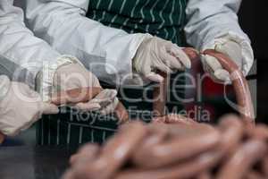 Butchers processing sausages