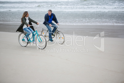 Couple riding bicycle on beach