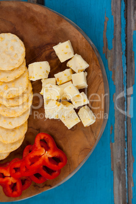 Cheese cubes, capsicum and biscuits on wooden board