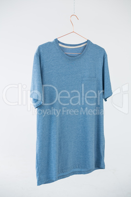 Blue t-shirt with pocket hanging on hanger