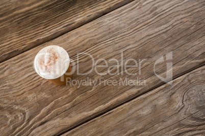 Coffee in disposable cup on wooden table