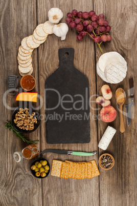 Bowl of green olives, bread, jam, rosemary herb, cheese and walnuts