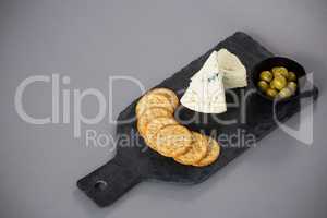 Cheese with biscuits and olives on slate plate
