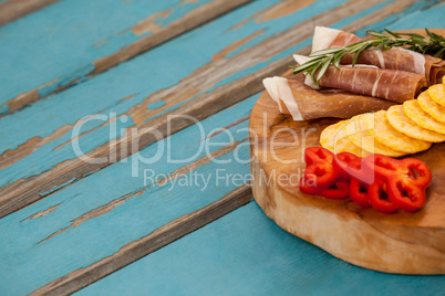 Capsicum, meat, rosemary and biscuits on wooden board