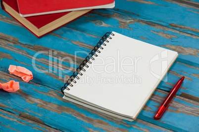 Notepad, pencil, red books and crumpled paper