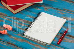 Notepad, pencil, red books and crumpled paper