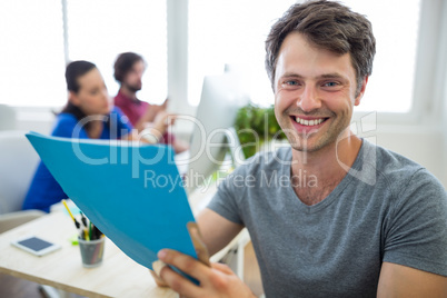 Portrait of smiling business executives holding file