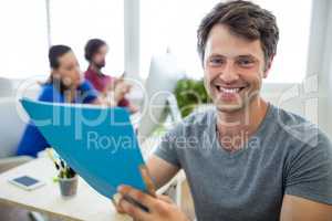 Portrait of smiling business executives holding file