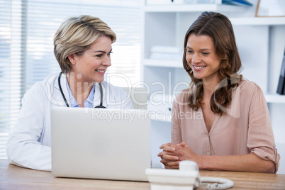 Doctor discussing with patient over laptop