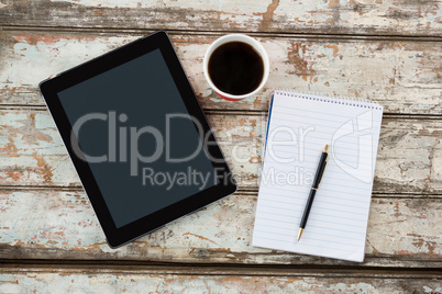 Digital tablet with notepad and cup of coffee