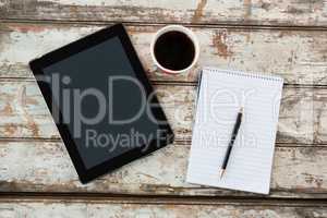 Digital tablet with notepad and cup of coffee