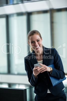 Smiling businessman holding a mobile phone